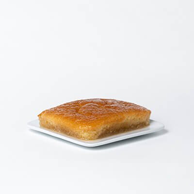 Gâteau pouding chômeur carré, servi sur une assiette carré blanche, sur fond blanc
