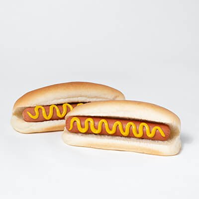 Deux hot-dogs cuits à la vapeur avec un filet de moutarde, sur fond blanc