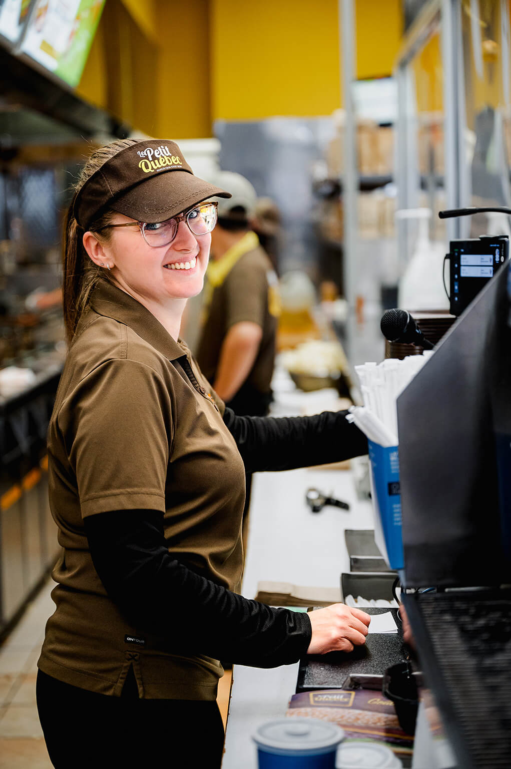 Woman at the counter in a fast-food restaurant with apron and cap